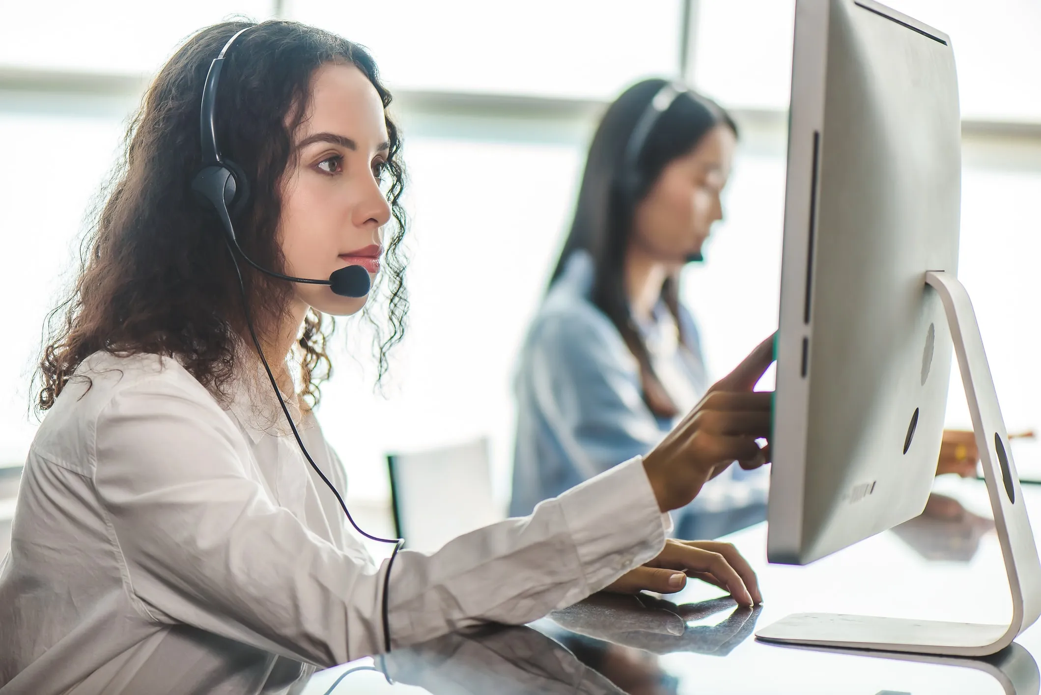 A nurse on a headset at a screen, taking the first call